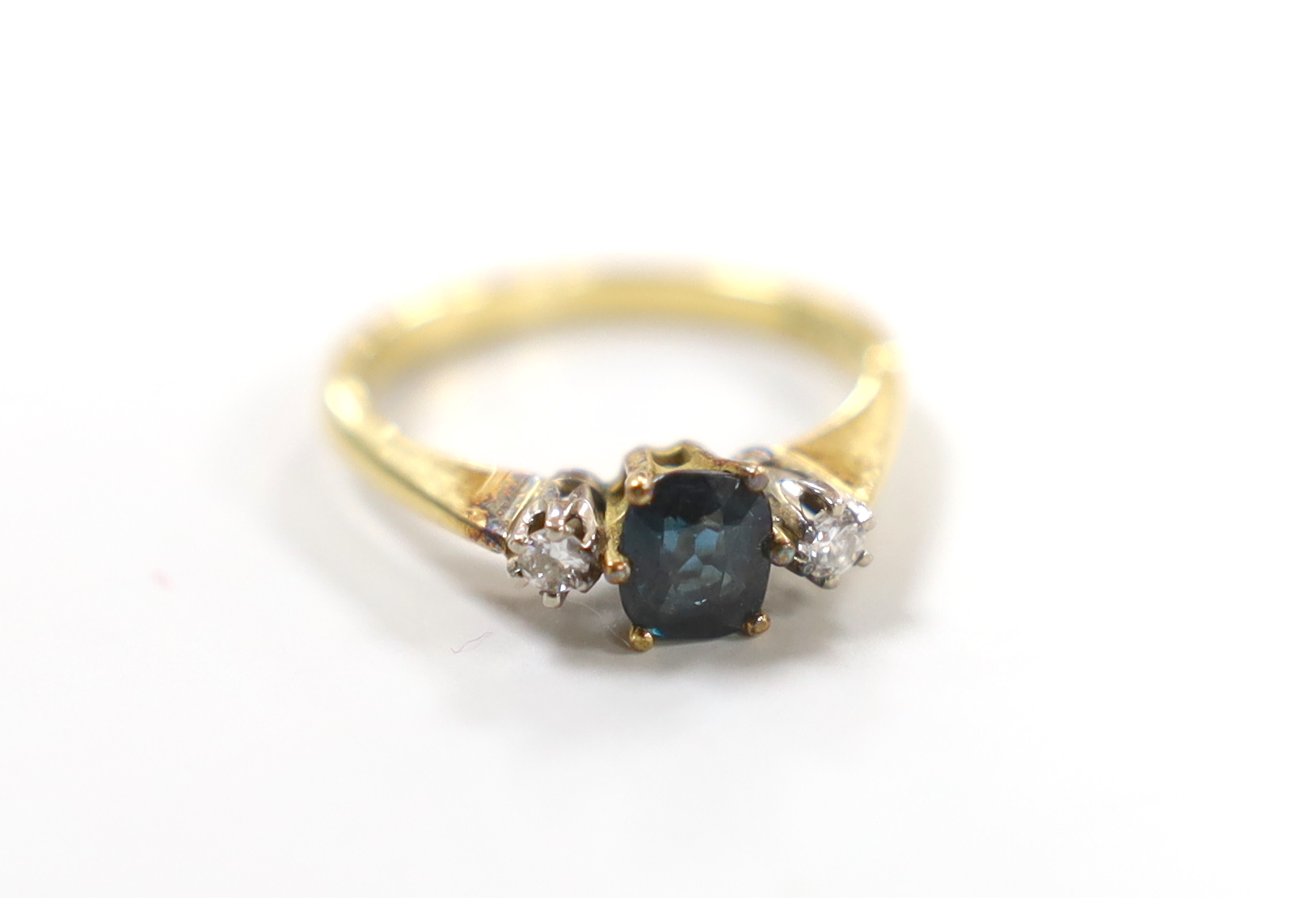 A modern 18ct gold, sapphire and diamond set three stone ring, size L, gross weight 2.7 grams.